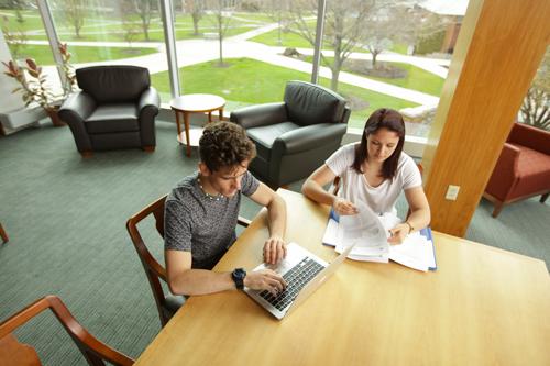 students looking at papers and computer